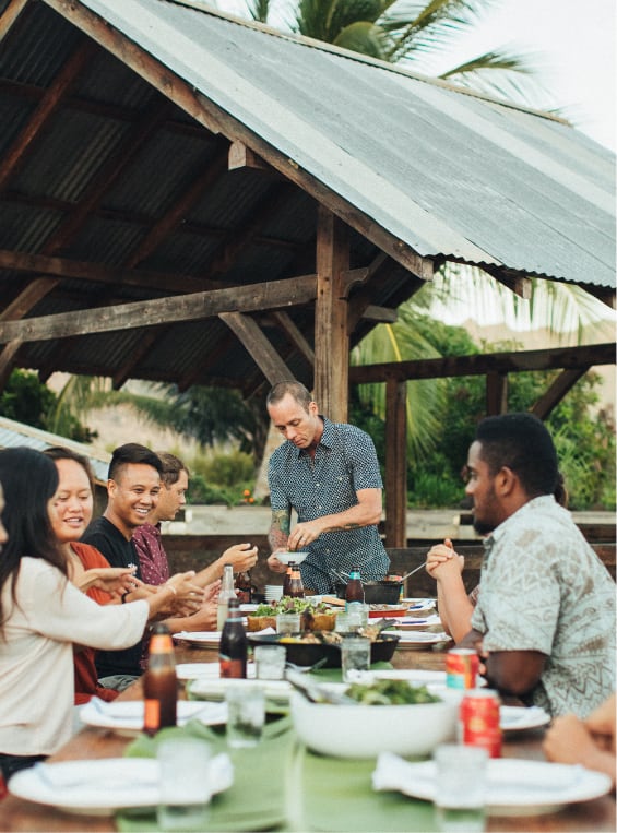 A group of friends sitting outdoors enjoying a meal together.